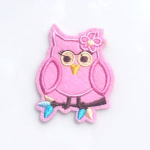 May include: Pink felt owl applique with a flower on its head and a branch with blue and white lights underneath.
