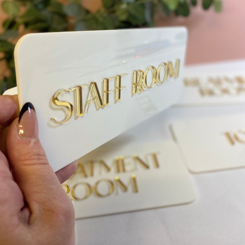 3D Acrylic business signage. Treatment room, staff room and toilet signs made from acrylic in gloss white with 3d mirror gold acrylic writing.