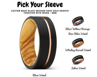 Puede incluir: Anillo de tungsteno negro cepillado con ranura de oro rosa y una incrustación de madera. Elija entre madera de olivo, madera de boj, madera de barril de whisky o madera de cebra.