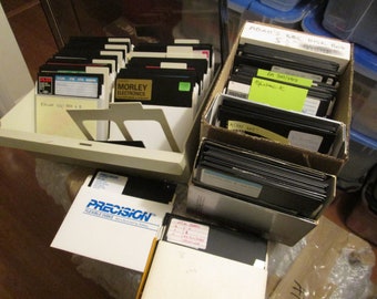 May include: A close-up of a collection of floppy disks organized in two boxes. The boxes are labeled "Adam's BBC Disk Box" and "Precision Flexible Disks".