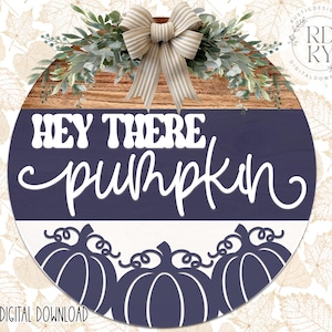 May include: A round wooden sign with a navy blue and white design. The sign reads "HEY THERE pumpkin" in white script. The sign is decorated with a bow, greenery, and pumpkin silhouettes. The sign is a digital download.