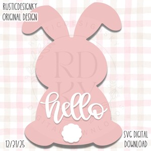 May include: A pink bunny-shaped design with the word "hello" in white script. The design includes a small white fluffy tail and is set against a pink and white checkered background. Text at the top reads "RUSTICDESIGNKY ORIGINAL DESIGN".