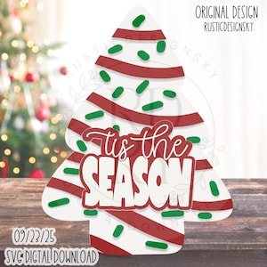 May include: A white Christmas tree-shaped design with red stripes and green sprinkles. The text "'tis the SEASON" is in the center. The design is a digital download, with the date 09/23/25 and the text "SVG DIGITAL DOWNLOAD" at the bottom.