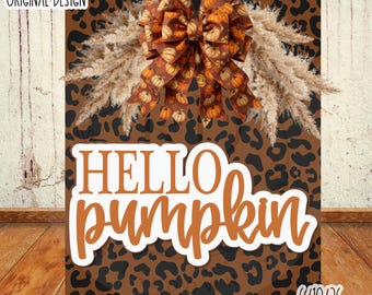 May include: A digital graphic design featuring a brown and black leopard print background with the text HELLO pumpkin in white and orange. A large decorative bow with a pumpkin pattern and beige pampas grass accents sits at the top centre.