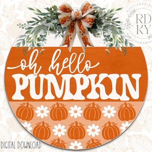 May include: A round, orange wooden sign with the text "oh hello PUMPKIN" in white. The sign is decorated with pumpkin and daisy patterns, and topped with greenery and a bow. The sign is a digital download.