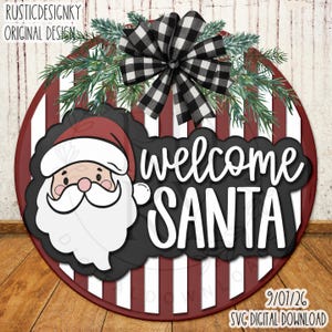 May include: A round sign featuring vertical maroon and white stripes, a black and white buffalo check bow, and green pine branches. It displays a cartoon Santa Claus face and the white text "welcome SANTA" on a black background.