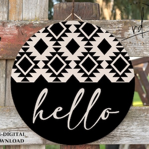 Puede incluir: Un letrero redondo de madera negro y blanco con un patr&oacute;n geom&eacute;trico y la palabra "hello" en una fuente de escritura.