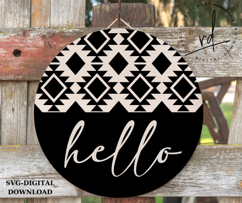 Puede incluir: Un letrero redondo de madera negro y blanco con un patr&oacute;n geom&eacute;trico y la palabra "hello" en una fuente de escritura.