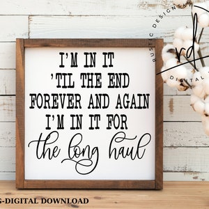 May include: A white wooden sign with black text that reads "I'm in it 'til the end forever and again I'm in it for the long haul".