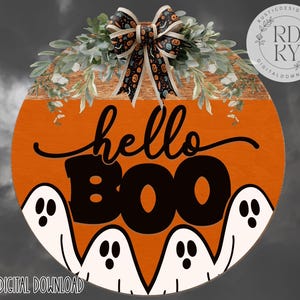 May include: Round orange Halloween sign with the words "hello BOO" in black script and block letters. The sign features white ghost figures at the bottom and is decorated with a bow and greenery at the top.