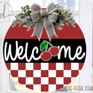 May include: A red and white checkered circle with the word "Welcome" in white text and a black and white checkered bow with two red cherries on top.