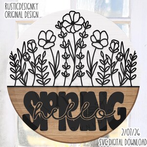 Puede incluir: Un letrero redondo de madera dividido en dos mitades. La mitad superior es blanca con recortes florales negros, la mitad inferior es marrón con la palabra "SPRING" en letras negras grandes y "hello" en cursiva. El texto incluye "RUSTICDESIGNKY ORIGINAL DESIGN" y "2/07/26 SVG DIGITAL DOWNLOAD".