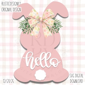 May include: A pink bunny-shaped design with a floral bow and greenery. The word "hello" is written in white script across the bunny's body. The design includes a white fluffy tail and the text "SVG DIGITAL DOWNLOAD".