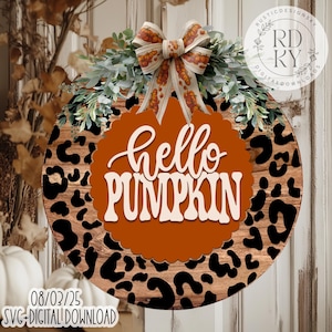 May include: Round wooden sign with a leopard print border and a central orange pumpkin shape. The sign says "hello PUMPKIN" in white script. It is decorated with a bow and greenery. The sign is a digital download.