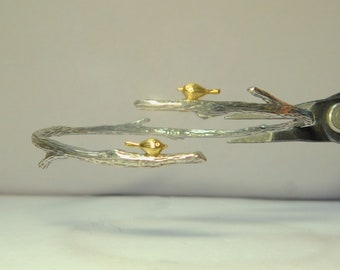 Bracciale con rami in argento sterling con aspetto simile al legno e due piccoli uccelli sugli arti.
