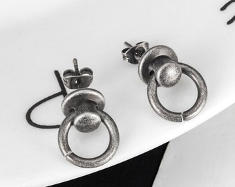 May include: A pair of silver-toned door knocker earrings. The earrings have a circular design with a raised knob in the center.