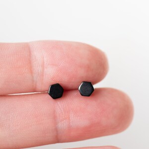 May include: A pair of black hexagonal stud earrings.