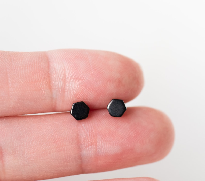 May include: A pair of black hexagonal stud earrings.