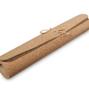 May include: A rolled up cork yoga mat tied with twine. The mat is brown and has a natural cork texture.
