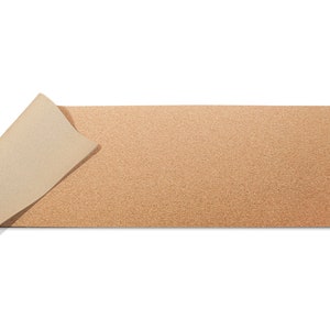 May include: A brown cork desk mat with a beige underside. The mat is rolled up on one side.