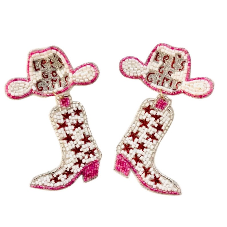 May include: A pair of beaded dangle earrings shaped like cowboy boots and hats. The white and pink hats feature the text Let's Go Girls in red beads. The white boots are decorated with a repeating pattern of red stars and have pink heels.
