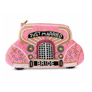 May include: A pink beaded clutch shaped like a vintage car, featuring the text JUST MARRIED above a grille and BRIDE on the license plate. The design uses white, gold, and black beads to outline the car's features, including headlights and trim.