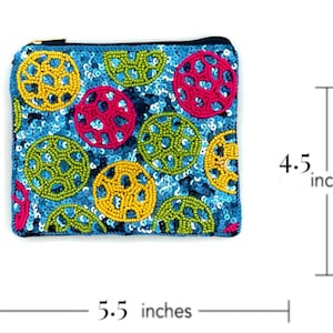 May include: A small, blue, beaded coin purse with a zipper closure. The purse is decorated with colorful circles of sequins and beads. It measures 5.5 inches wide and 4.5 inches tall.