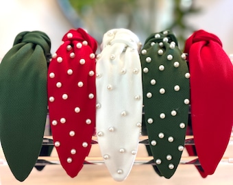 Op de afbeelding: Vijf stoffen hoofdbanden met parelversiering. De hoofdbanden zijn in groen, rood, wit en twee tinten groen.