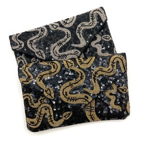 May include: Two black sequined clutches with a snake pattern. The top clutch has silver snakes and the bottom clutch has gold snakes.