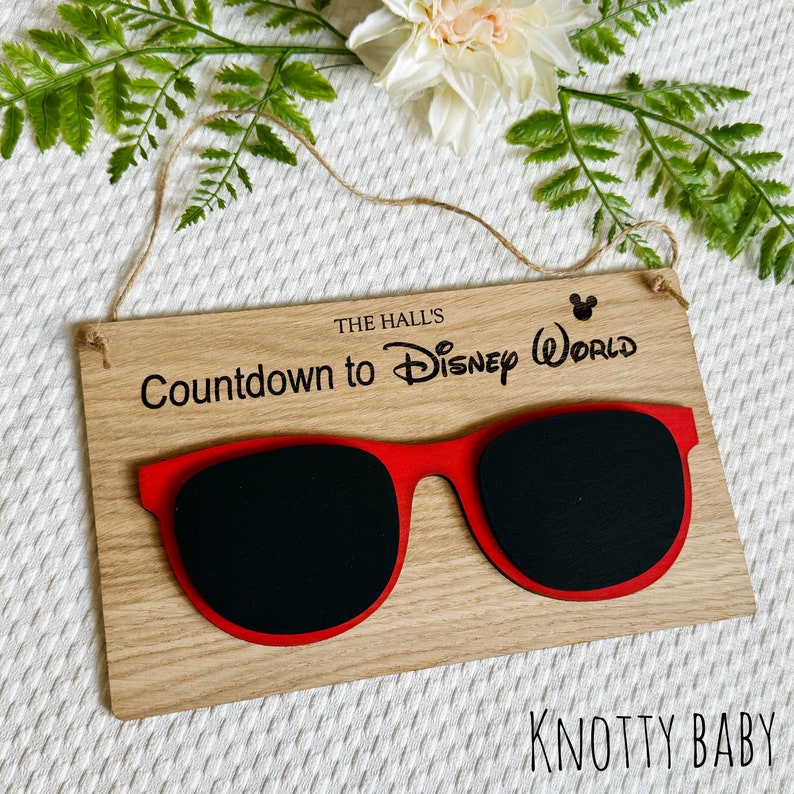 May include: Wooden countdown sign with red sunglasses and the text "The Hall's Countdown to Disney World" with a Mickey Mouse icon.