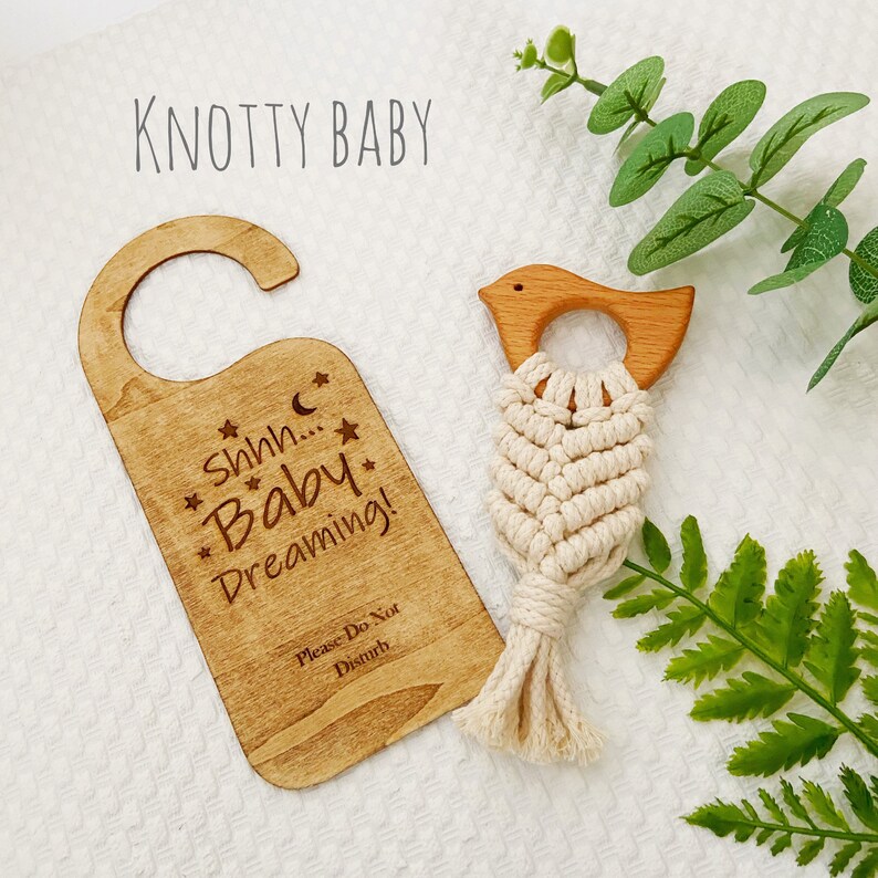 May include: A wooden door hanger with the text "Shhh... Baby Dreaming!" and "Please Do Not Disturb". A wooden bird with a knotted rope hanging from it.