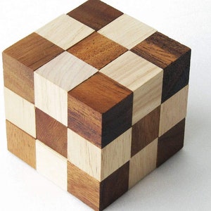 K&ouml;nnte beinhalten: Ein Holzw&uuml;rfelpuzzle mit einem Schachbrettmuster aus hellem und dunklem Holz. Der W&uuml;rfel besteht aus kleineren W&uuml;rfeln, die gedreht und neu angeordnet werden k&ouml;nnen.