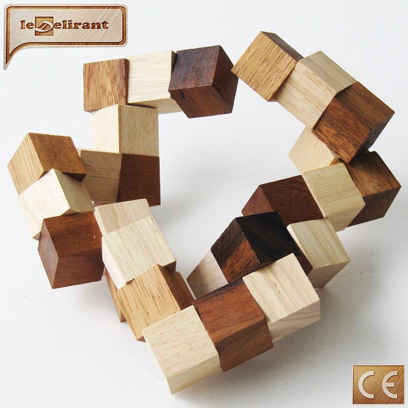 K&ouml;nnte beinhalten: Ein Holzpuzzle aus 16 kleinen W&uuml;rfeln, die jeweils zwei unterschiedlich farbige Seiten haben. Die W&uuml;rfel sind in einem Kreis angeordnet, wobei die unterschiedlich farbigen Seiten nach au&szlig;en zeigen. Das Puzzle ist aus hellem und dunklem Holz.