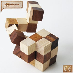 K&ouml;nnte beinhalten: Ein Holzpuzzle mit einem Schachbrettmuster. Das Puzzle besteht aus kleinen W&uuml;rfeln, die bewegt und neu angeordnet werden k&ouml;nnen. Das Puzzle ist im Begriff gel&ouml;st zu werden, einige W&uuml;rfel sind bereits an der richtigen Stelle.