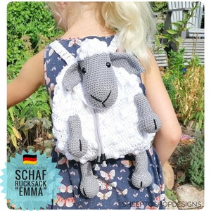 Könnte beinhalten: Ein weißer Häkel-Rucksack in Form eines Schafes mit grauen Akzenten. Der Rucksack hat einen Reißverschluss und ein süßes Schafgesicht. Der Rucksack wird von einem Kind getragen.