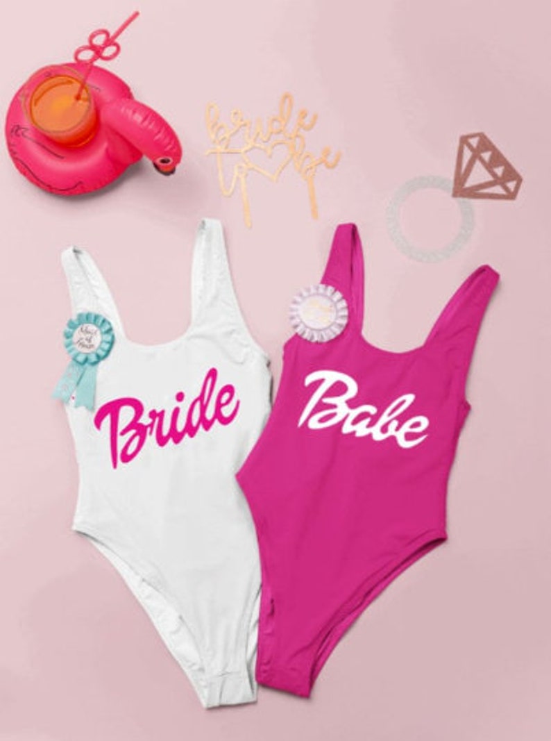 Bride and babe one piece bachelorette party swimsuits in white, hot pink, for a barbie themed bachelorette party bachelorette swimsuits
