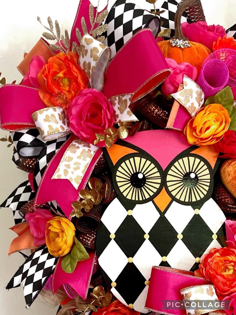 May include: A pink and black checkered owl wreath with pink, orange, and white flowers, gold glitter, and a pink bow.