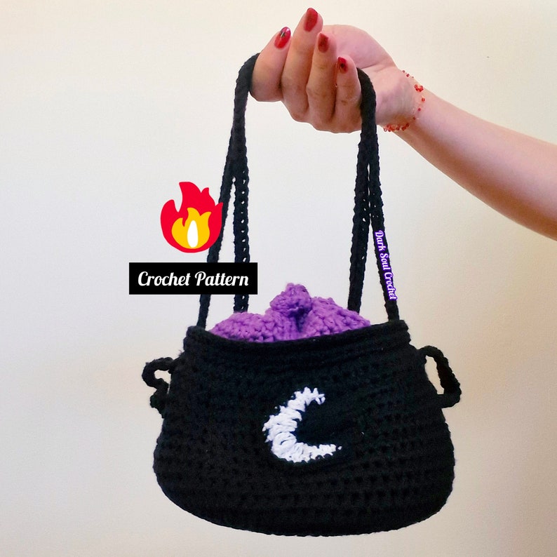 Witch Crochet Cauldron Bag with 2 straps, purple bubbles and crescent moon logo on the bag.