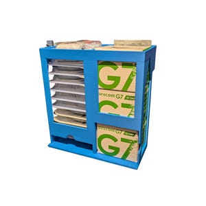 May include: A bright blue plastic storage organiser featuring a vertical column of shelves on the left side and two stacked compartments on the right. The right side holds boxes labelled Dexcom G7 15 Day. The top surface holds medical supplies.