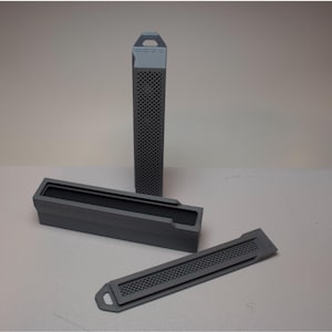 May include: Three gray rectangular containers. One is tall and slender with a perforated design. The other two are shorter, with one open and the other a lid. All have a matte finish and a handle or tab.