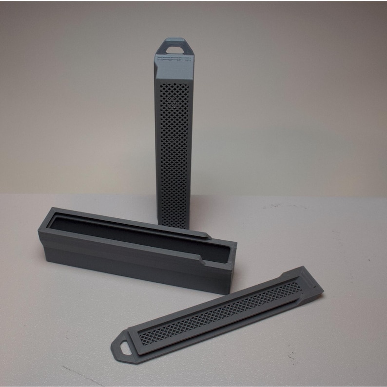 May include: Three gray rectangular containers. One is tall and slender with a perforated design. The other two are shorter, with one open and the other a lid. All have a matte finish and a handle or tab.