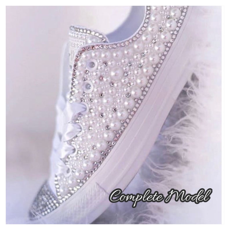 K&ouml;nnte beinhalten: Wei&szlig;e Canvas-Sneaker mit Perlen- und Strassbesatz. Die Schuhe sind mit Perlen und Strass besetzt und erzeugen so einen funkelnden Effekt.
