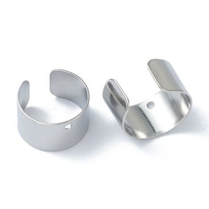 May include: Two silver-colored ear cuffs. Each cuff is a curved band with an opening on one side and a small hole. The cuffs are made of a shiny, metallic material and are displayed against a white background.