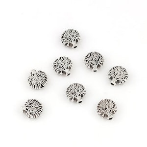 May include: Silver-colored hedgehog charms with detailed etched designs. These small, round charms are arranged on a white surface, showcasing their intricate features. Ideal for jewelry making or crafting projects.
