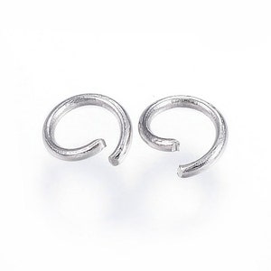May include: Two silver-colored open jump rings, essential components for jewelry making and crafting. The rings are circular with a small gap, ready to be connected to other jewelry findings. The bright, metallic finish suggests durability and a modern aesthetic.