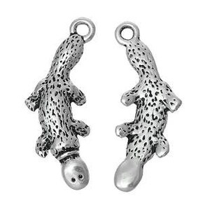 May include: Two silver-colored charm pendants in the shape of a lizard or salamander. Each charm has a textured body with small holes, four stubby legs, and a loop at the top for attaching to a chain or bracelet. The pendants are displayed against a white background.