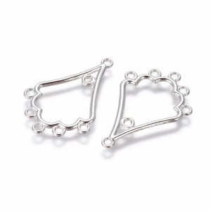 May include: Two silver-colored metal chandelier earring connectors. Each connector has a unique, openwork design with multiple small loops for attaching beads or other components. The connectors have a scalloped edge.