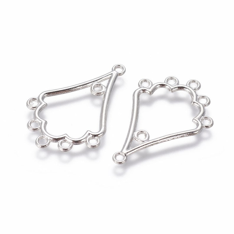 May include: Two silver-colored metal chandelier earring connectors. Each connector has a unique, openwork design with multiple small loops for attaching beads or other components. The connectors have a scalloped edge.
