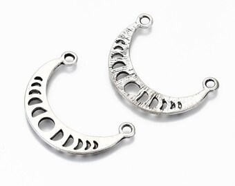 May include: Two silver-colored crescent moon charms. Each charm features a phase-of-the-moon design with various cut-out shapes and a loop at each end for attaching to jewelry. The charms have a textured, antique finish.