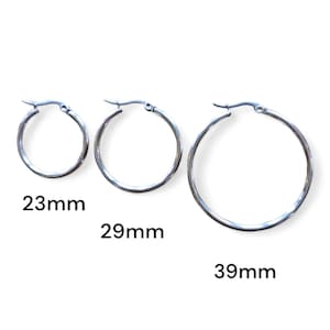 Peut inclure: Trois boucles d'oreilles cr&eacute;oles argent&eacute;es de diff&eacute;rentes tailles : 23 mm, 29 mm et 39 mm. Les boucles d'oreilles sont pr&eacute;sent&eacute;es sur un fond blanc. Les cr&eacute;oles ont un design simple et classique.